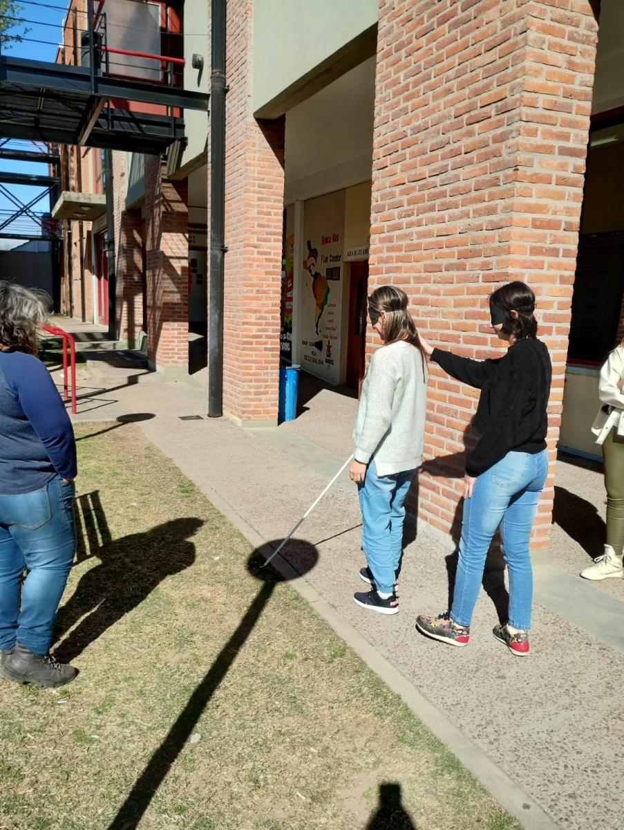 Estudiantes realizando un recorrido con los ojos vendados y con baston por el Centro Regional