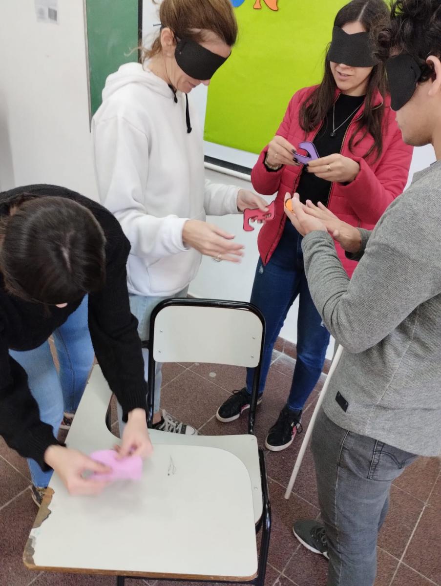  Estudiantes reconocientos letras para pegar la frase dada en un afiche  con los ojos vendadosonal